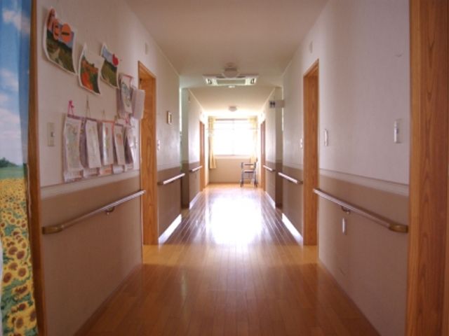 光差し込む廊下 廊下 自然光が降り注ぐ、明るく広々とした廊下です。安全な移動をサポートする手すりが設置されています。