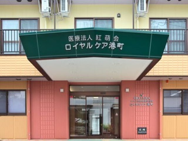 エントランスの看板 玄関 温かみのある色合いで、入る人を穏やかに迎えるエントランスです。スタッフの皆様が、日々の活動でお待ちしております。