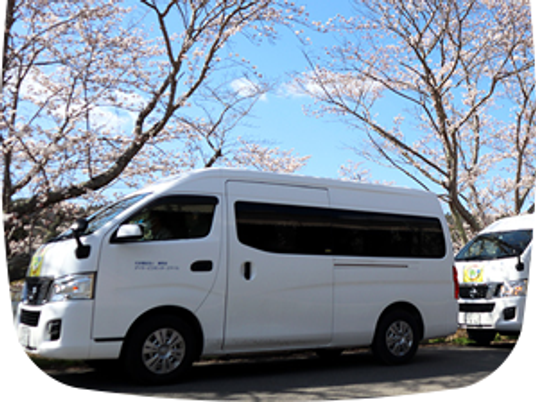 送迎車と桜並木の外観  