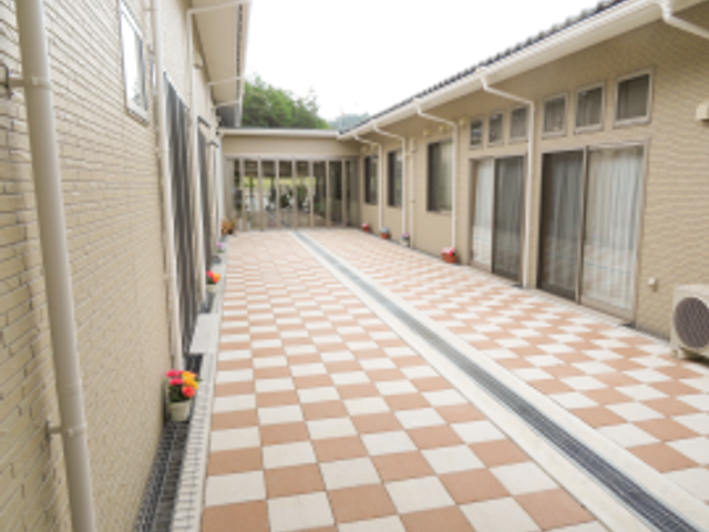 花が飾られた廊下 廊下 明るく開放的な廊下です。季節ごとの花々が並び、職場環境を彩ります。