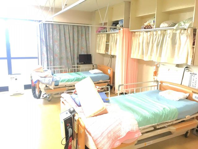 明るい二人部屋の居室 居室 自然光が差し込む居心地の良い二人部屋です。棚には収納スペースも豊富に備わっています。