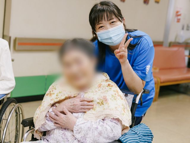 笑顔のやりとり廊下 廊下 活気ある廊下で、スタッフが利用者と親しく交流しています。丁寧なサポートを感じます。
