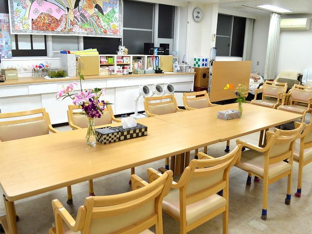 広々としたダイニングルーム ダイニングルーム   大きなテーブルと椅子が並んだダイニングスペースです。花が飾られ、明るく居心地の良い雰囲気になっています。