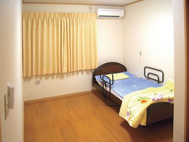 ベッドとエアコンの居室 居室   シンプルで落ち着いた居室です。エアコンが完備され、一年中快適に過ごせます。