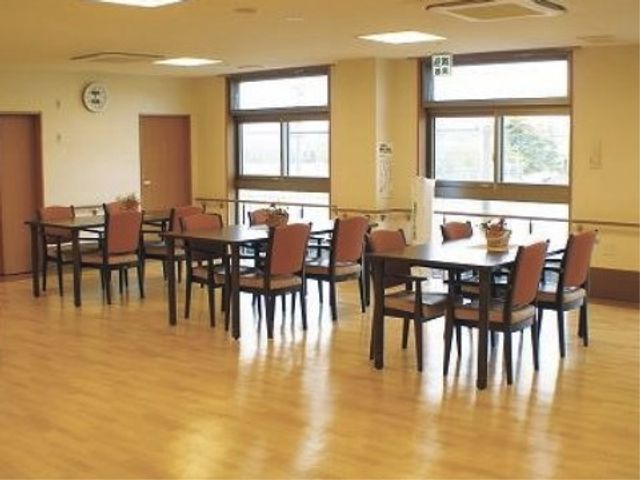 明るい共用ダイニングルーム リビング 広々とした明るい食堂で、利用者さまが会話を楽しみながら食事ができます。窓から差し込む自然光が心地よい空間を演出しています。