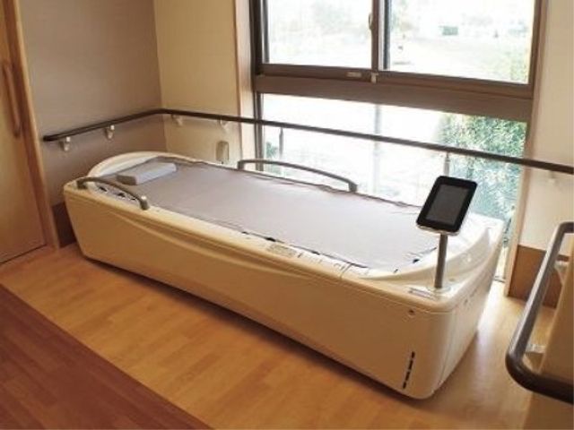 快適な設備の浴室 機能訓練室 ゆったりとしたバリアフリー設計の浴室。温かみのある照明と木目調の床で落ち着いた雰囲気です。
