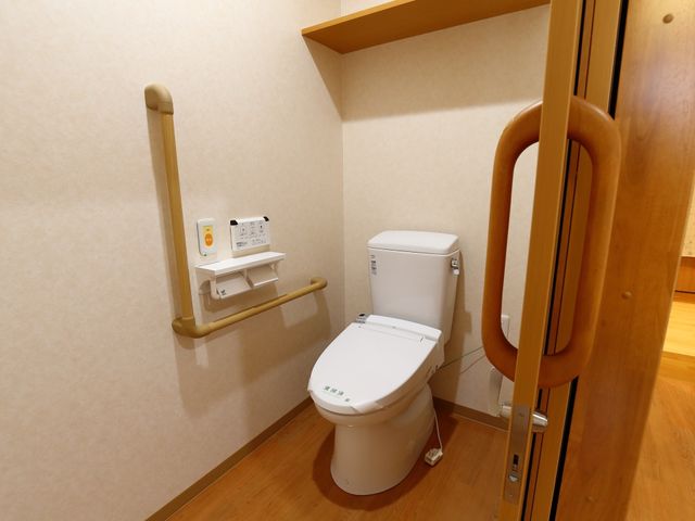 バリアフリートイレ設備 トイレ ゆとりあるスペースのトイレには、支え棒が設置されており、安心してお使いいただけます。扉も手すり付きで、開閉がしやすくなっています。