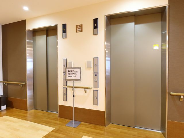 施設のエレベーターホール エレベーター 手すりが設置されたエレベーターホールは、安全かつ快適にご利用いただける設計となっています。動線も考慮されており、日々の移動がスムーズです。
