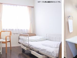 明るい居室のベッドと机  