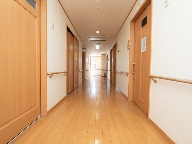 廊下の明るい通路 通路 床に反射する光が心地よい廊下です。手すりが備え付けられ、安心して歩行できる設計になっています。