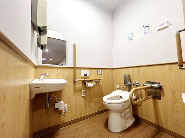 機能的な空間のトイレ トイレ 明るく清潔な個室には手すりが配置されており、安全を考慮した設計です。利用者の安心をサポートします。