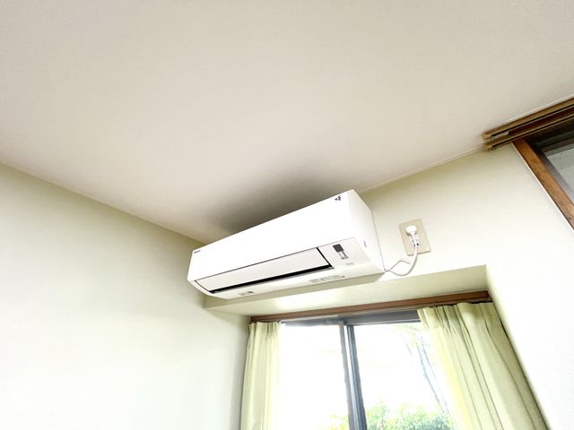 白い天井のエアコン エアコン 快適な室温を保つエアコン設備です。自然光が差し込む窓があり、明るく風通しの良い空間です。