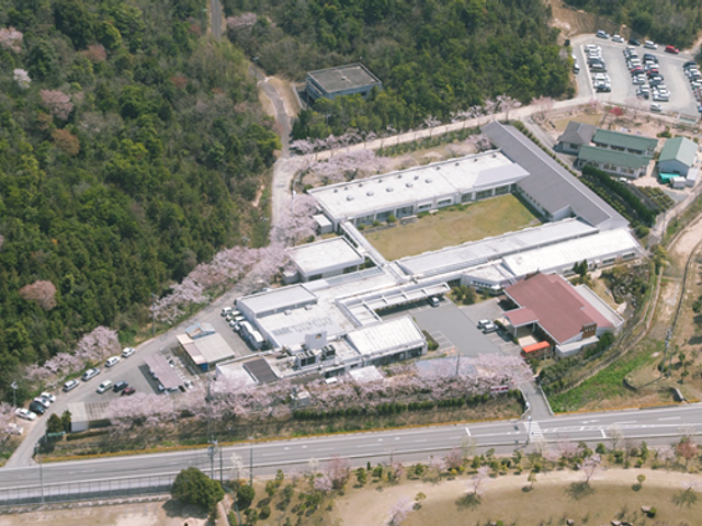 桜に囲まれた建物 外観 広大な敷地に建つ施設で、周囲には桜が満開です。開放的な雰囲気で、自然に親しめます。