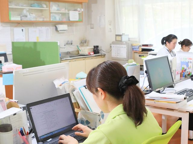 スタッフが働くオフィス スタッフイメージ 職員が机に向かい、パソコンで業務に取り組んでいます。明るい空間で作業もはかどります。