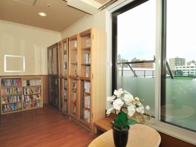 本棚と窓のある空間 図書館 開放的な窓辺のスペースは、読書や静かなひとときを過ごすのに理想的です。光が降り注ぐこの場所で、ゆったりとした時間をお過ごしいただけます。