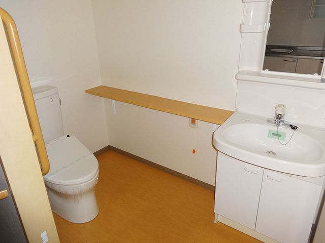 シンプルな洗面とトイレ トイレ 清潔感のある洗面台とトイレのスペースです。安全に配慮した手すりが設置されており、快適な日々のサポートが整っています。