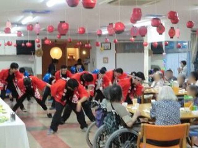 お祭りイベントの食堂 イベント 明るい雰囲気の食堂では、イベントも盛んに行われ、居住者の方々のコミュニケーションが活発です。舞踊を披露するスタッフの姿から、楽しい日々を過ごせることが伺えます。