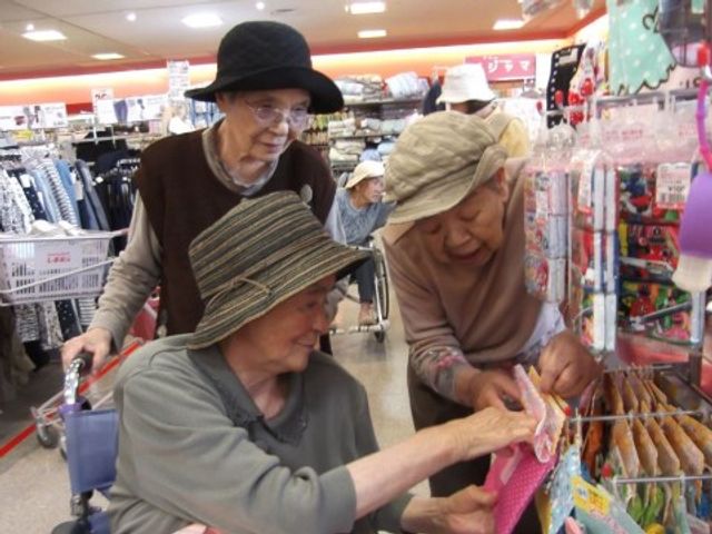 買い物を楽しむ高齢者 レクリエーション ケアサポートの一環として、外出時のお手伝いを行う様子です。共に買い物を楽しみながら、日常生活の充実をサポートしています。