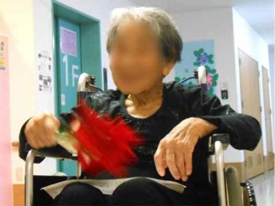 廊下で手遊びをする利用者