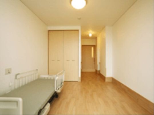 白を基調とした壁と木の色を用いた戸や床が温かみのある居室である。広々とした室内に入居者様のお好きな家具を入れて、快適にお過ごしいただける。
