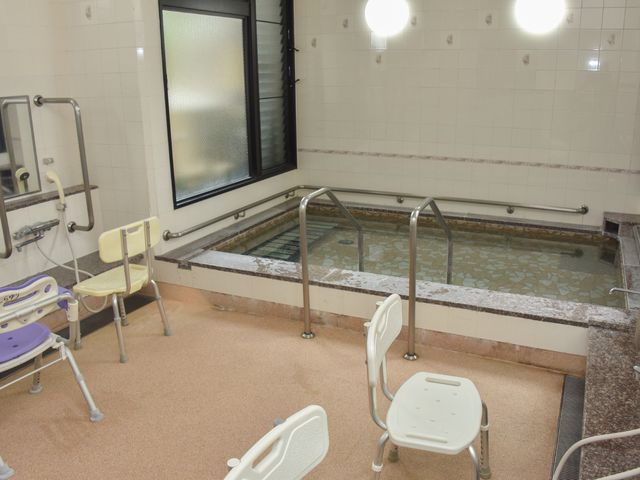 バリアフリーの浴室空間 大浴場 手すりや椅子を備えた清潔な浴室で、安心して快適な入浴が楽しめます。利用者のケアに配慮した設計が特長です。
