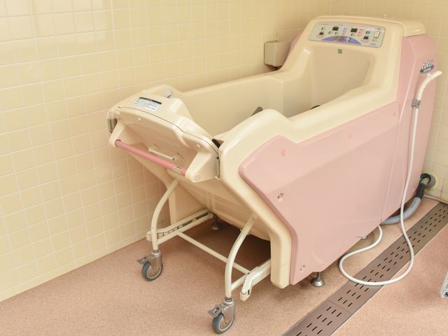 ピンク色の快適浴槽 機械浴槽 ゆったりとしたバリアフリー設計の浴槽があり、安心してご利用いただける環境です。