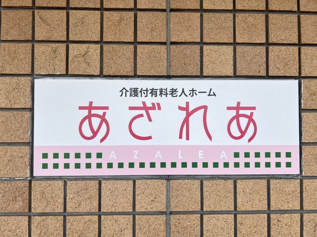 明るい色の看板 看板 温かみのある色合いの看板が、皆様を優しく迎え入れてくれます。安心してお過ごしいただける空間です。