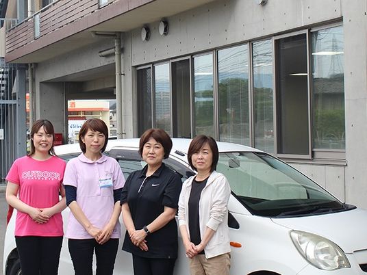 スタッフ4人と車の外観  
