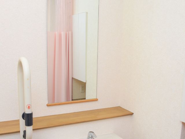 手すり付き洗面台 洗面所 手すりが設置された清潔感のあふれる洗面スペースです。使用者の安全と快適性を考えた設計になっています。