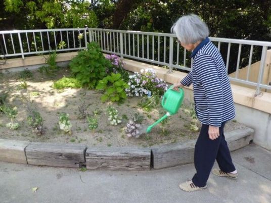 お花に水をやる高齢者