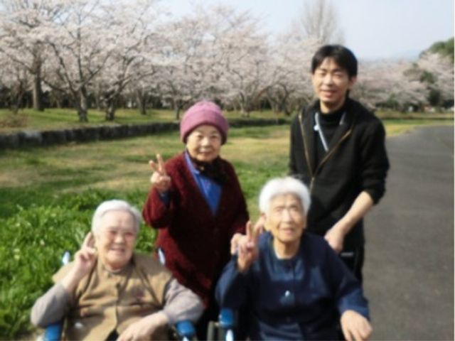 公園で和やかな様子 レクリエーション 共有スペースの緑あふれる公園で、利用者が心温まるひとときを過ごされています。安らぎを与える屋外空間でのコミュニケーションも充実しています。