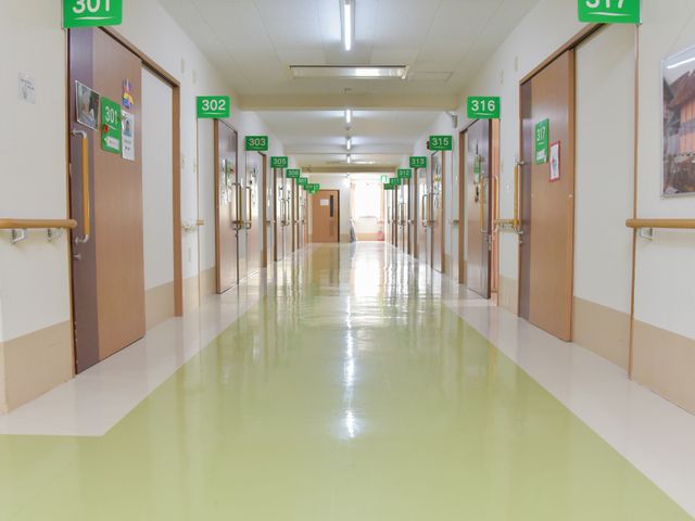 清潔な廊下の風景 廊下 光が差し込む廊下は清潔感があり、ナンバリングされた扉が並んでいます。手すりも完備しており、安心して歩ける環境です。