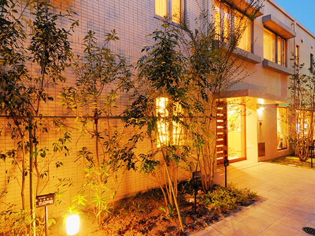 温かみのある建物外観 外観 庭に囲まれた温かみのある建物です。入り口には明るい照明が設置されています。