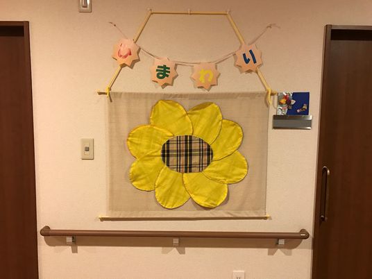 布で作った、ひまわりの工作を展示している。季節によってさまざまな工作を行っているので、楽しんでいただける。