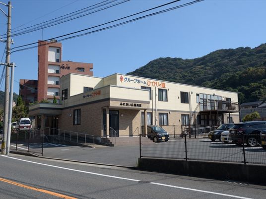茶系統のモダンな建物である。手すりの付いた階段とスロープが完備されている。周辺は山に囲まれた静かな環境である。
