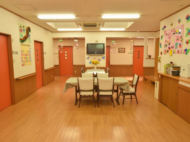 食堂の装飾された空間 リビング 壁には飾り付けがあり、コミュニケーションの場として暖かい雰囲気です。