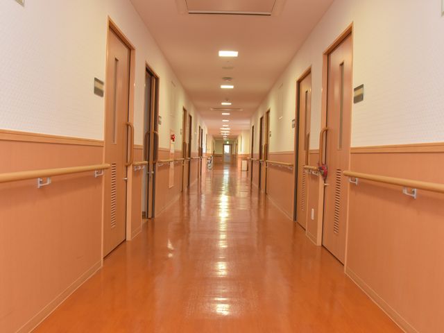 清潔感溢れる廊下の風景 廊下 手すりが設置された広々とした通路です。明るく清潔な環境が保たれ、安心して歩行できる様子が伺えます。