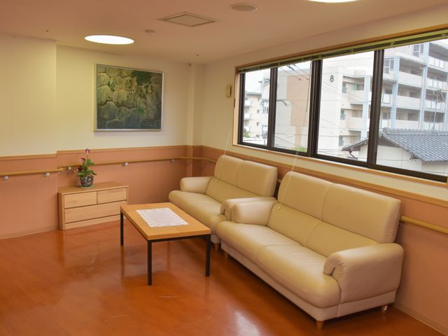 快適な待合ロビー ダイニング ゆったりくつろげるベージュのソファが設置された、落ち着いた雰囲気の待合スペースです。窓から自然光が差し込む明るい空間で、訪れる方を暖かくお迎えします。