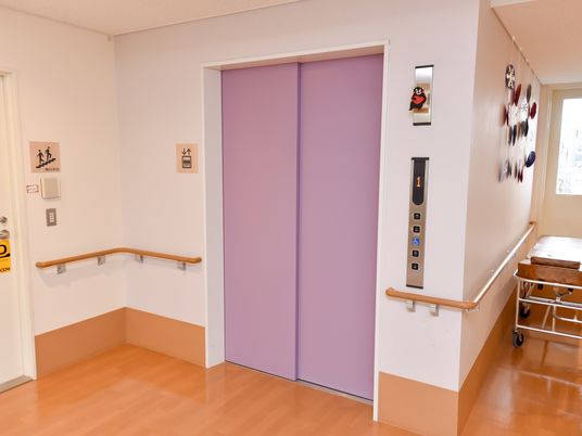 紫色の扉と手すりの廊下