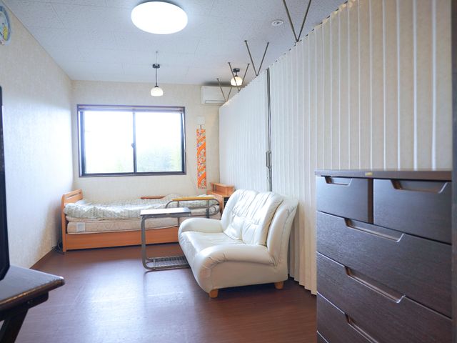 居心地の良い居室 居室 陽光が差し込む暖かい雰囲気の居室です。心地よいソファとベッドが配置され、リラックスできる空間となっています。