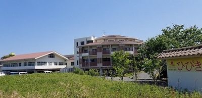 緑に囲まれた建物の外観  