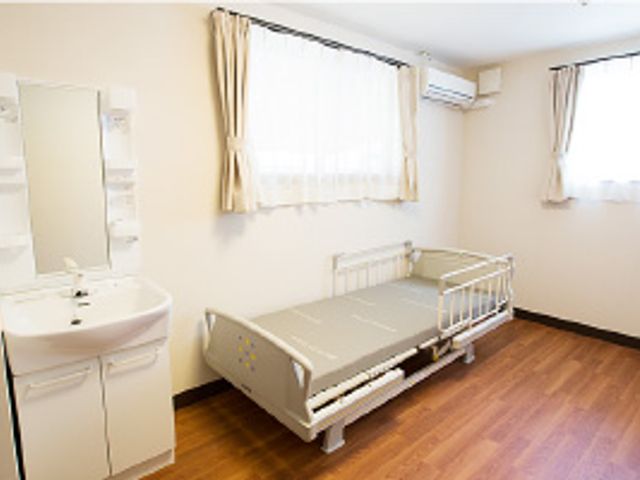 居心地の良い居室風景 居室 ゆったりとした床の間と清潔感ある洗面台が配置された居室です。ベッド周りも広く、日々の生活が快適に過ごせる設計になっています。