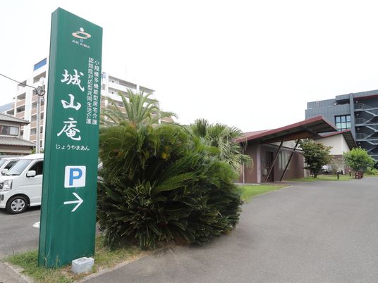 緑豊かな看板横の道