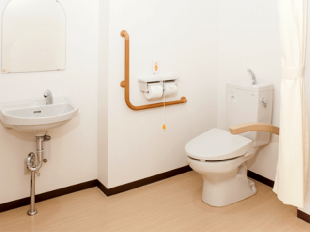 落ち着いたトイレ空間 トイレ 安全な手すりが設置された安心感のあるスペースです。利用者の方のために快適さを考えた設計になっています。