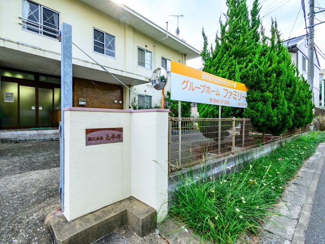 外観の見取り図 外観 落ち着いた色合いの建物前に立つ案内看板。訪れる方々を穏やかな雰囲気で迎えます。