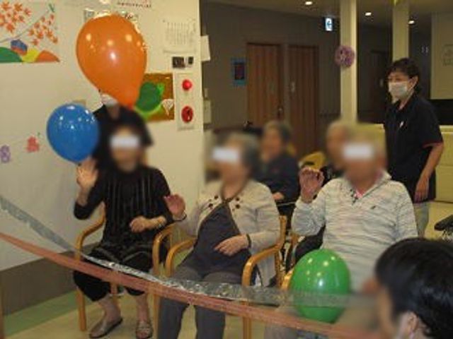 イベント楽しむ人々の部屋 多目的室 楽しげな雰囲気の中、バルーンを使ったゲームをみなさんで楽しんでいます。賑やかな交流が感じられる空間です。