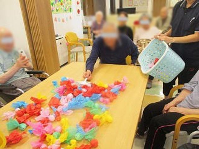楽しむ利用者たちの様子 多目的室 色とりどりのアイテムを使い、活気あふれる交流の場になっています。楽しさが溢れています。
