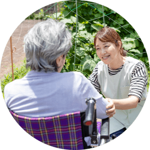 笑顔の介護士と利用者　庭