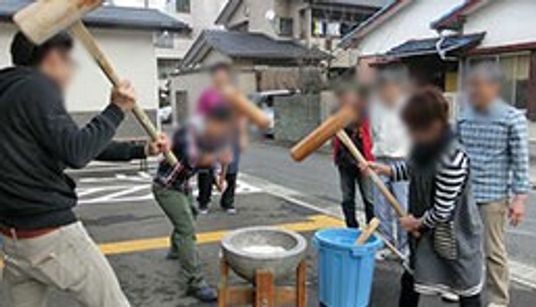 屋外で餅つきをする人々の様子