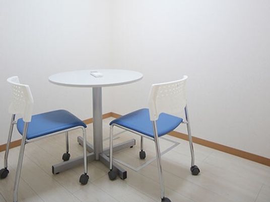 白いテーブルと青い椅子がある部屋
